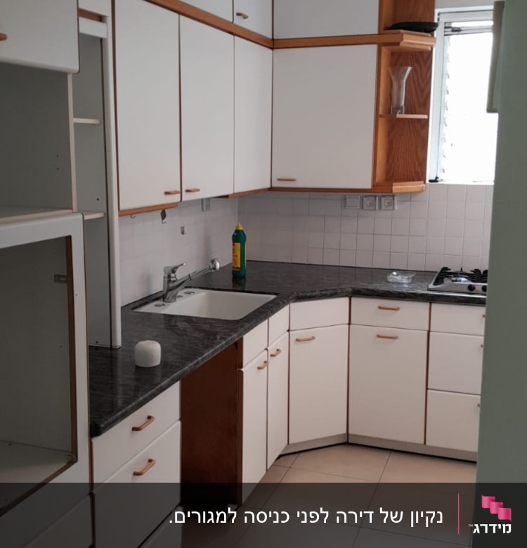 בקבוק חומר ניקוי ליד כיור במטבח
